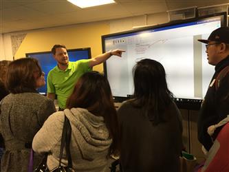 A man pointing to material on a smartboard