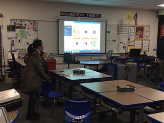 A teacher setting up a presentation in a classroom