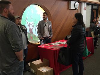 People speaking to a man at a table